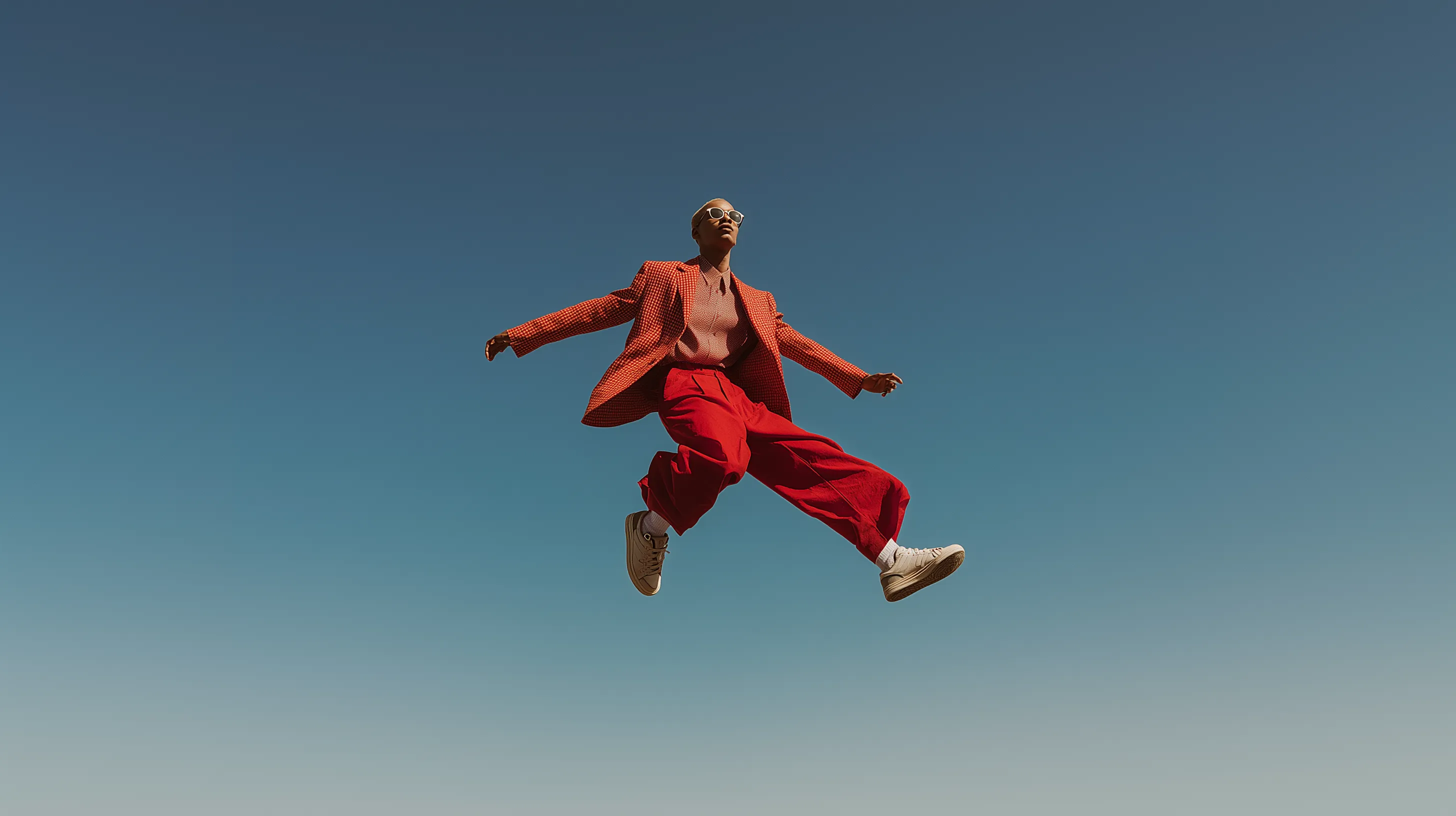 HI Assessments Agile by Design - Person jumping dynamically against blue sky symbolizing agility and freedom in talent assessment solutions